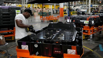An assembly line worker uncrates an LG battery at the General Motors Orion Assembly, Thursday, June 15, 2023, in Lake Orion, Mich. On Friday, the U.S. government issues the October jobs report.