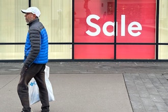 A shopper passes a clothing store in the Thornton Premium Outlets, Thornton, Colo., Dec. 18, 2023.