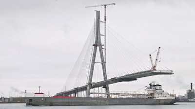 The freighter Manitowoc passes by construction on the Gordie Howe International Bridge, Detroit, Dec. 29, 2023.
