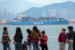 A container ship passes tourists in Xiamen, China, Dec. 26, 2023.