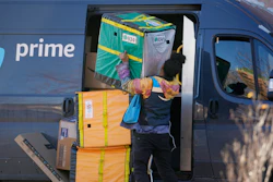 An Amazon Prime driver lifts packages during a stop at a Denver high-rise, Nov. 28, 2023.