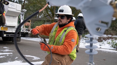 A worker from Portland General Electric replaces a power line in Lake Oswego, Ore., Jan. 16, 2024.