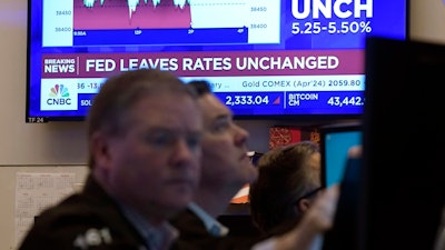 A television screen on the floor of the New York Stock Exchange displays the Federal Reserve's decision on interest rates, Jan. 31, 2024.