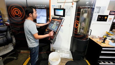 A worker at Reata Engineering and Machine Works programs a Mazak Variaxis machine used to make semiconductor pieces, Feb. 15, 2024, Englewood, Colo.
