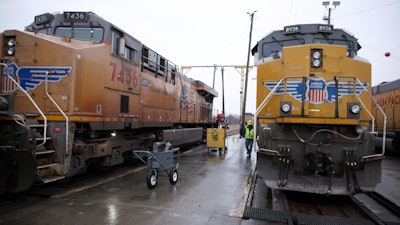 A Union Pacific worker walks between two locomotives, Council Bluffs, Iowa, Dec. 15, 2023.