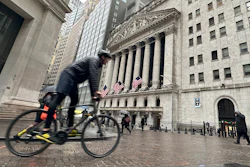 A bicyclist passes the New York Stock Exchange, March 5, 2024.