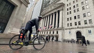 A bicyclist passes the New York Stock Exchange, March 5, 2024.