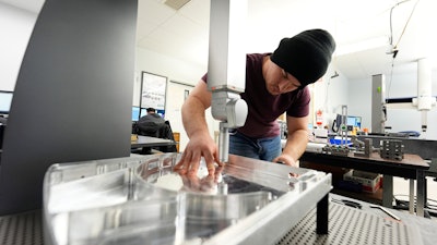 A worker prepares a Hexagon machine at Reata Engineering and Machine Works, Englewood, Colo., Feb.15, 2024.