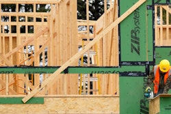 A construction workers cuts wood at a residential building site in Mount Prospect, Ill., March 18, 2024.