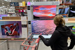 A shopper passes a display of televisions at a Costco warehouse, Lone Tree, Colo., April 29, 2024.