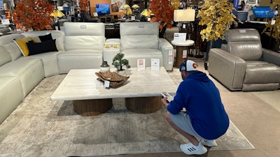 A shopper pauses at a display in a furniture store in Englewood, Colo., June 2, 2024.