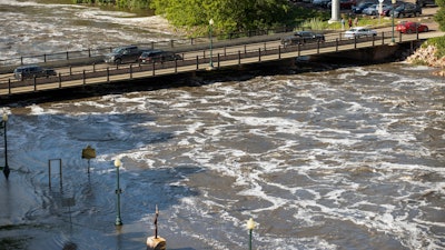 Water flows dangerously under the Falls Park Drive bridge at Falls Park, Sioux Falls, S.D., June 22, 2024.