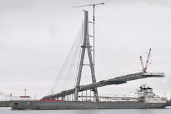 The freighter Manitowoc makes its way down the Detroit River past construction on the Gordie Howe International Bridge, Dec. 29, 2023.
