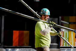 A construction worker carries scaffolding parts, Boston, March 14, 2024.