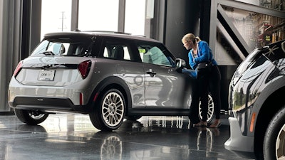A prospective buyer looks over a 2025 Cooper S hardtop at a Mini dealership in Highlands Ranch, Colo., July 22, 2024.