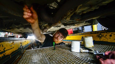 Ian Frank, a pit technician at Stop & Go on Putney Road in Brattleboro, Vt., changes the oil on a vehicle, July 15, 2024.
