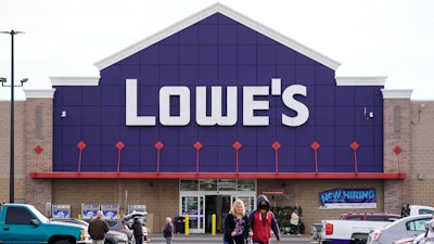 Shoppers walk in the lot of a Lowe's home improvement store in Philadelphia, Wednesday, Nov. 17, 2021.