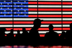 People gather near an electronic display of an American flag in Times Square, New York, Aug. 9, 2024.