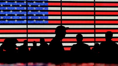 People gather near an electronic display of an American flag in Times Square, New York, Aug. 9, 2024.