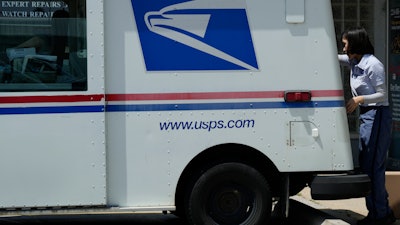A U.S. Postal Service employee makes deliveries in Northbrook, Ill.