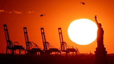 Cranes at the Port of New York and New Jersey appear behind the Statue of Liberty, Nov. 20, 2022.