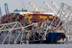 The cargo ship Dali is stuck under part of the structure of the Francis Scott Key Bridge after the ship hit the bridge, Tuesday, March 26, 2024, as seen from Pasadena, Md.