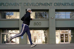 In this Dec. 18, 2020, file photo a runner passes the office of the California Employment Development Department in Sacramento, Calif.
