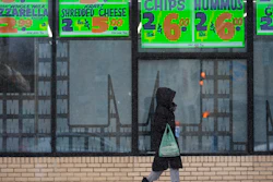 A person walks by a grocery store during a winter storm in Chicago, Feb. 12, 2025.
