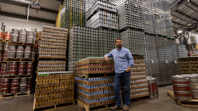Jeff Ware, president of Resurgence Brewing Company, poses for a portrait near a stockpile of aluminum cans, which are sourced from Canada, Thursday, Feb. 27, 2025, in Buffalo, N.Y.
