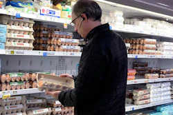 A shopper checks eggs at a grocery store in Glenview, Ill., Jan. 10, 2023.
