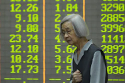 An investor stands in front of stock price indices at a brokerage house, Hangzhou, China, April 7, 2025.