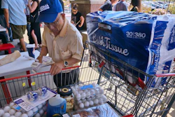 A customer checks his shopping receipts while waiting in line at the food court at Costco store, Glendale, Calif., April 10, 2025.