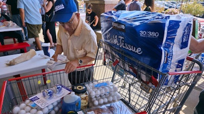 A customer checks his shopping receipts while waiting in line at the food court at Costco store, Glendale, Calif., April 10, 2025.