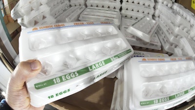 A shopper selects a carton of 18 Large Grade A eggs from a cooler in a Costco Warehouse in Cranberry, Pa., Jan. 28, 2025.