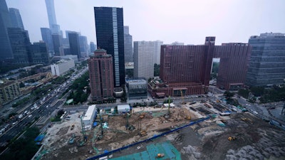 Earth movers transport soil at a construction site in Beijing, July 11, 2025.