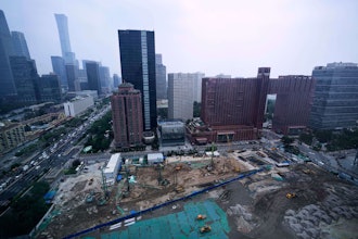Earth movers transport soil at a construction site in Beijing, July 11, 2025.