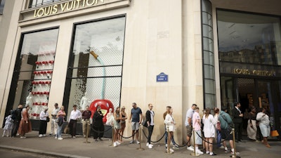 People queue outside the Louis Vuitton store, Paris, July 28, 2025.