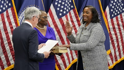 Lisa Cook, right, takes the oath of office to become a member of the Federal Reserve Board, May 23, 2022, Washington.