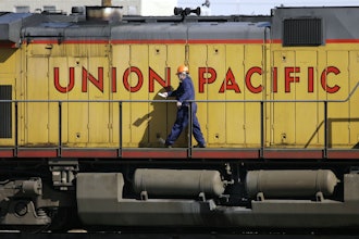 A maintenance worker walks past a locomotive in the Union Pacific Railroad fueling yard in north Denver, Oct. 18, 2006.