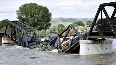Train cars are immersed in the Yellowstone River after a bridge collapse near Columbus, Mont., June 24, 2023.