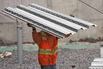 A construction worker carries steel decking at a construction site, Portland, Maine, July 31, 2025.