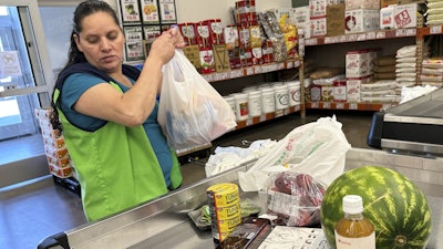 An employee works at a cash register in a grocery store in Schaumburg, Ill., Sept. 18, 2025.