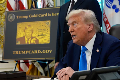 A poster showing the Trump Gold Card is seen as President Donald Trump signs executive orders in the Oval Office of the White House, Friday, Sept. 19, 2025, in Washington.