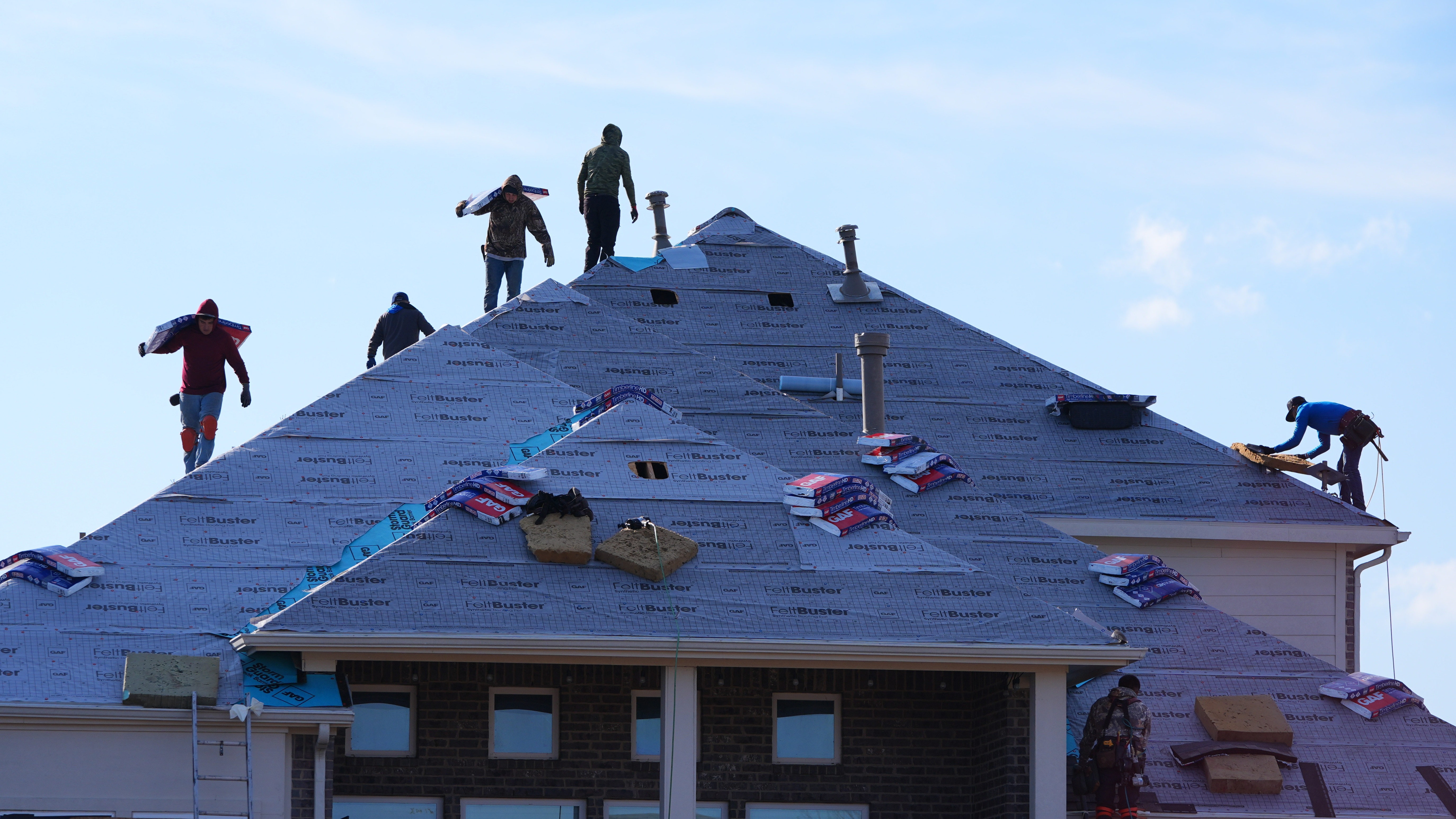 Roofers work atop a house in Anna, Texas, Dec. 18, 2025.