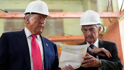 Federal Reserve Chairman Jerome Powell, right, and President Donald Trump look over a document of cost figures during a visit to the Federal Reserve, July 24, 2025, Washington.