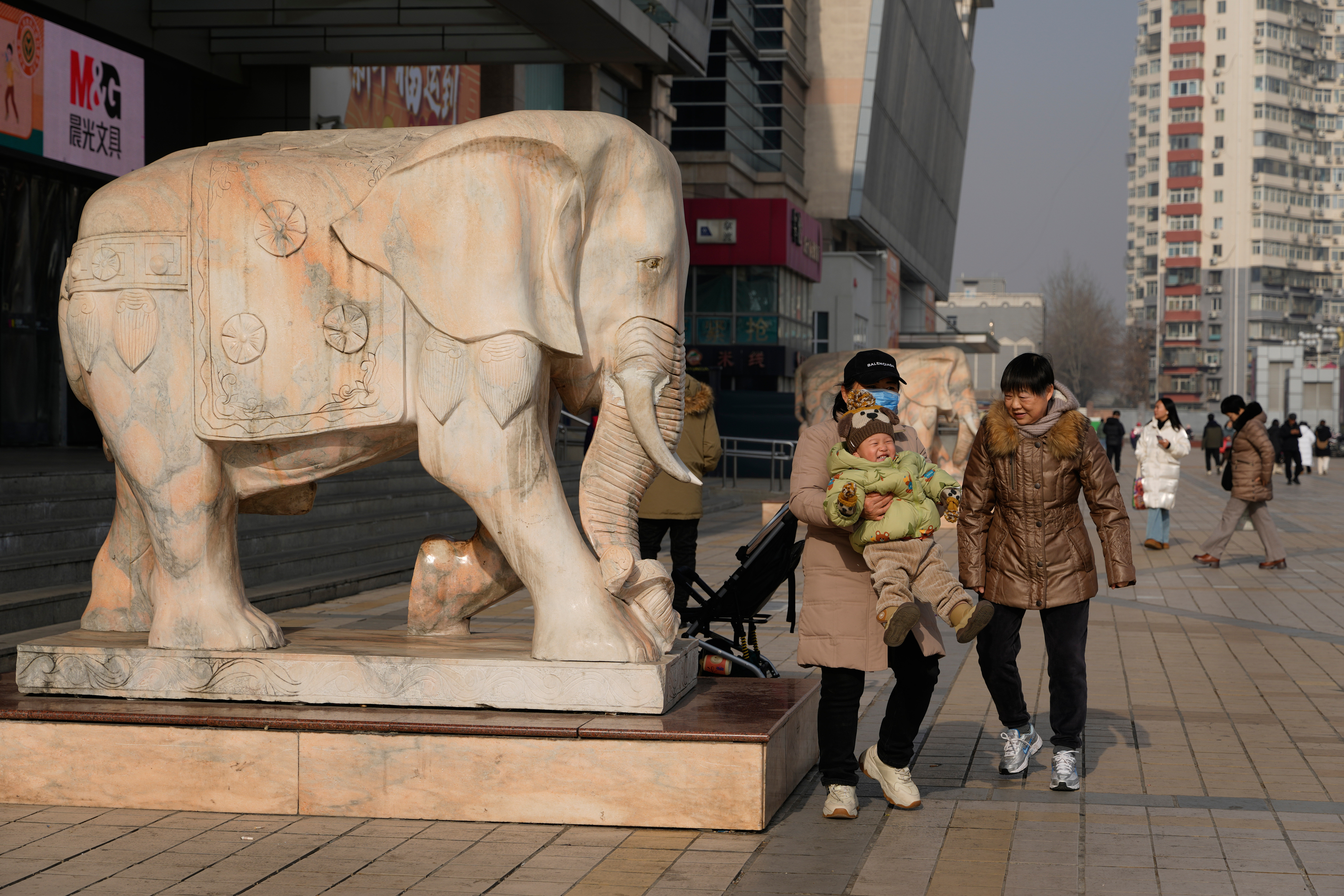 A woman lifts up a child in Beijing, Jan. 15, 2026.