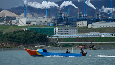 A boat cruises past a nickel processing plant at Indonesia Weda Bay Industrial Park in Central Halmahera, North Maluku province, Indonesia, June 8, 2024.