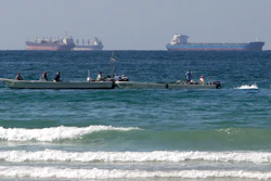 Fishermen work in front of oil tankers south of the Strait of Hormuz, Jan. 19, 2012, off Ras Al Khaimah, United Arab Emirates.
