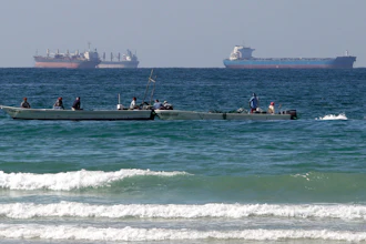 Fishermen work in front of oil tankers south of the Strait of Hormuz, Jan. 19, 2012, off Ras Al Khaimah, United Arab Emirates.