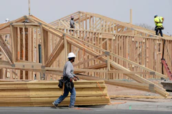 Construction workers install a lumber roof at a new home build, April 1, 2025, Laveen, Ariz.